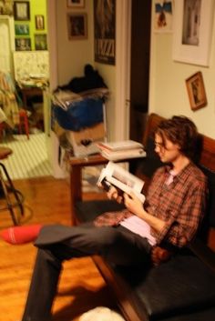 a person sitting on a couch reading a book