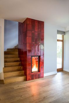 a fire place sitting on top of a wooden floor next to a stair case in a living room