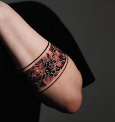 a woman's arm with a tattoo on it and a red flower in the middle