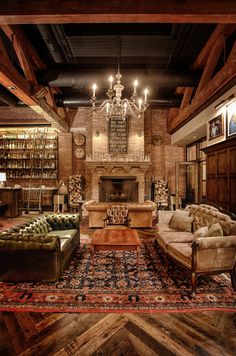 a living room filled with lots of furniture and a chandelier hanging from the ceiling