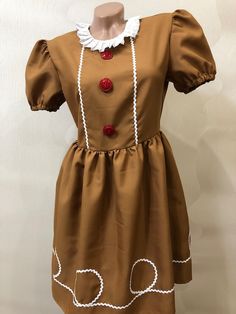 a brown dress with white trim and red buttons