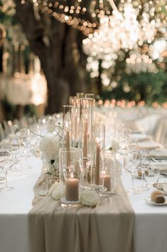 the table is set with candles, flowers and wine glasses for an elegant wedding reception