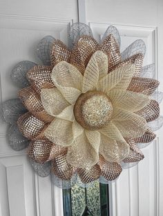 a large metal mesh flower hanging from the side of a door