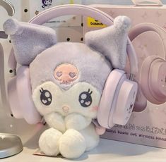 a stuffed animal with headphones on it's ears sitting next to a box