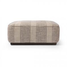 a small ottoman that is sitting on top of a white surface with a brown stripe pattern