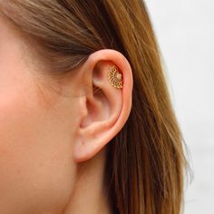 a close up of a person's ear with an earring in the shape of a flower