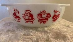 a bowl with santa claus on it sitting on top of a white table next to a wall