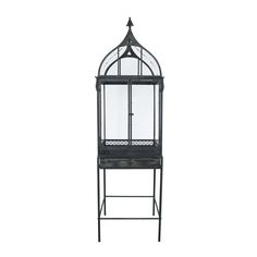 a black metal birdcage with glass doors on the top and bottom shelf, against a white background