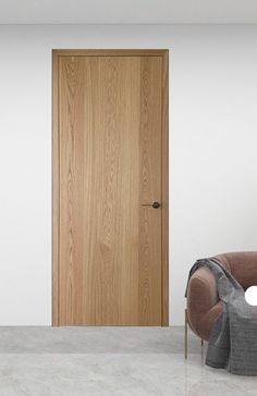 an empty room with a chair and wooden door