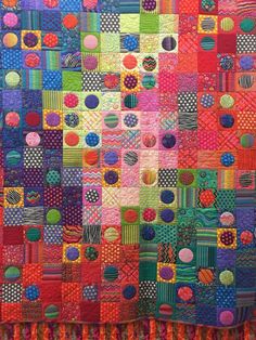 a colorful quilt is hanging on the wall