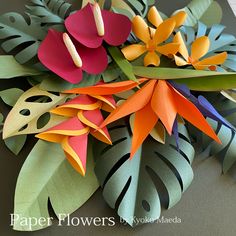 some paper flowers and leaves on a table