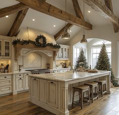 a large kitchen with an island in the middle and christmas trees on the counter top