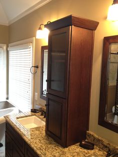 a bathroom with marble counter tops and wooden cabinet in the middle, along with a tub