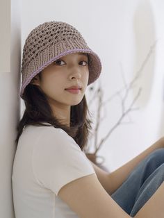 a woman sitting on the floor wearing a hat