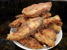 some fried food on a white plate on a black counter top with brown sugar sprinkles