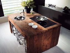 a kitchen island with two bowls on it and a stove top in the middle that is made out of wood