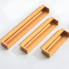 three gold shelfs sitting next to each other on a white surface with no one in them