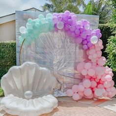 there are balloons in the shape of a letter and a seashell on the ground