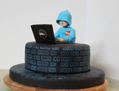 a cake made to look like it has a laptop on top of it and a person in a blue hoodie