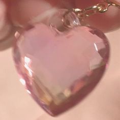 a person holding a pink heart shaped necklace