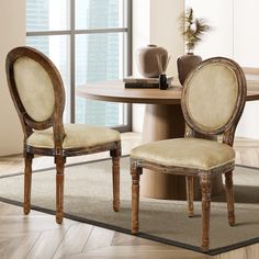 a dining room table with two chairs and a rug