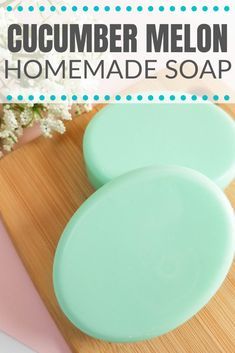 two soap bars sitting on top of a wooden cutting board next to flowers and a vase