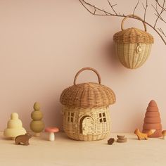 two wicker baskets hanging on the wall next to small wooden toys and tree branches