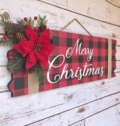 a red and black plaid christmas sign with poinsettis hanging from the front