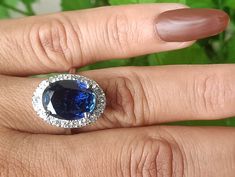 a woman's hand with a ring on it and a blue stone in the middle