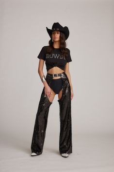 Channel your inner cowgirl in these one-of-a-kind Hartley Sequin Chaps. The perfect finishing touch to your festival outfit, these pants are adorned with black sparkles and complete with a belted waistband and straight-leg fit. Just add shorties, cowboy boots, and a crop top. Cochella Cowgirl Outfit, Cowgirl Pants Outfit, Cowboy Pants Outfit, Cowgirl Chaps Outfit, Women Festival Outfits, Cowboy Rave Outfit, Rockstar Cowgirl Outfit, Assless Chaps Outfit Festival, Leather Chaps Outfit