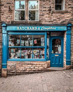 a blue store front with lots of books on it's windows and the words hatchard & daughters written in english