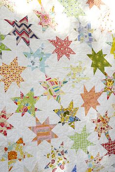 a large quilt with many different colored stars on it