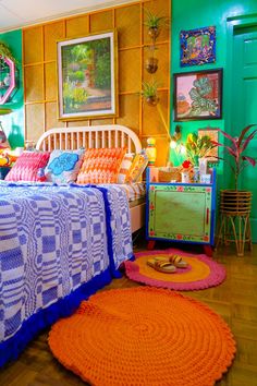 a bedroom decorated in bright colors with an orange rug on the floor and green walls