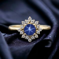 a gold ring with a blue stone surrounded by diamonds