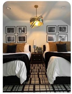 two beds in a room with pictures on the wall and lamps hanging above each bed