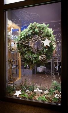 a christmas wreath is displayed in a window