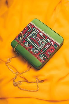 a green purse sitting on top of a yellow blanket