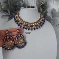 Regal and timeless antique gold reverse polki modern Indian jewelry set done in a  sabyasachi inspired design with NAVY BLUE accent beading is available for purchase. Full set comes with easy to wear long chandelier earrings, tikka and necklace for countless wears!  DRAWSTRING closure for a custom fitted neckline. The perfect hand crafted jewelry is sure to compliment your next outfit this season and next! Wear the pieces together or seperately for endless options. Our beautiful Indo-western des Luxury Blue Kundan Jewelry, Blue Meenakari Bridal Necklace In Temple Jewelry Style, Blue Meenakari Temple Jewelry Set, Blue Bridal Necklace In Temple Jewelry Style With Meenakari, Blue Temple Jewelry Set With Meenakari, Blue Temple Jewelry Bridal Necklace With Meenakari, Blue Meenakari Chandbali Bridal Necklace, Bollywood Blue Bridal Necklace Hand Set, Heavy Blue Bridal Necklace For Diwali