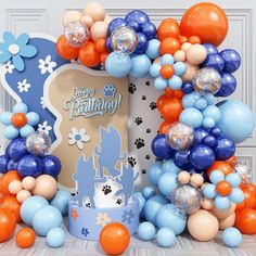 a birthday cake surrounded by balloons and streamers in front of a white door with an animal theme