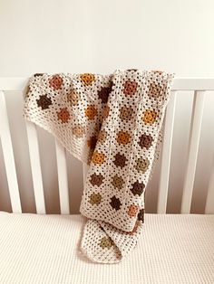 a crocheted blanket on top of a white crib