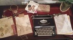 an old fashioned typewriter sitting on top of a table next to some paper and other items