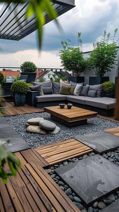 an outdoor living area with wooden furniture and plants on the roof top deck, surrounded by gravel