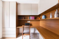 a desk with a laptop on it in a small room next to bookshelves