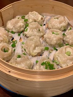 some dumplings are sitting in a bamboo steamer