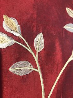 a close up view of a red fabric with white and gold flowers on the side