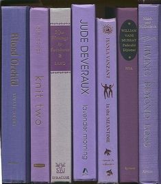 a row of purple books sitting on top of each other