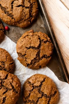 chocolate cookies are on a baking sheet with wax paper next to them and a red pepper