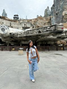 a woman standing in front of a star wars ship at disney's hollywood studios