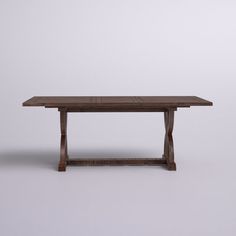 a wooden table sitting on top of a white floor next to a gray wall in an empty room