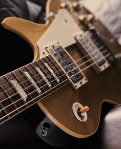 an electric guitar sitting on top of a bed